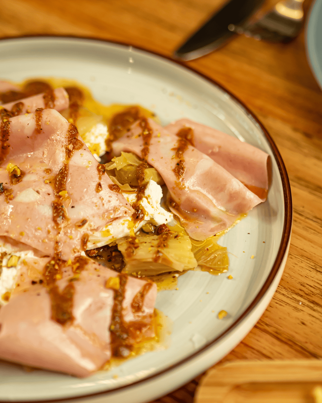 Burrata con puerro asado y mortadela de Bolonia en finas láminas